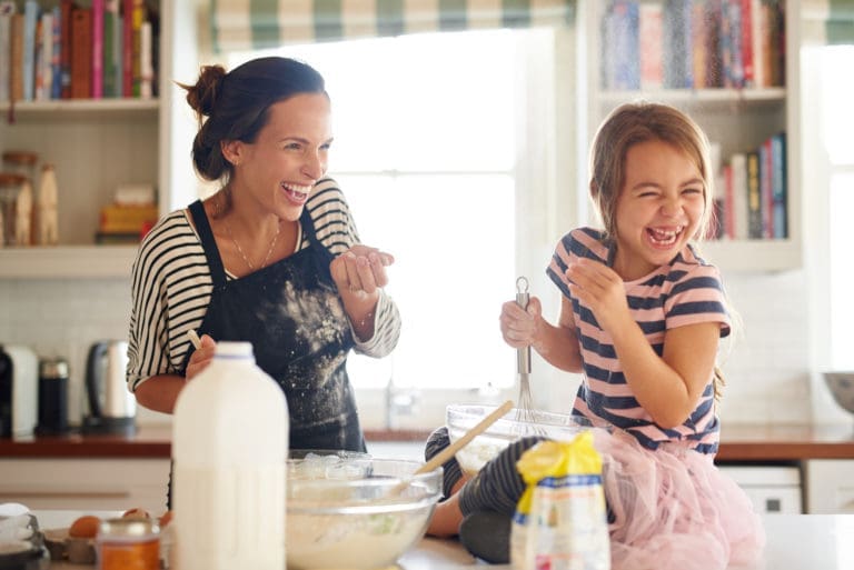 Daughter having fun baking with her mother in the kitchen