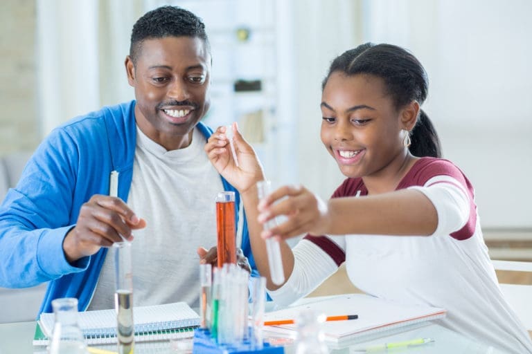 Teacher helping student with science experiment