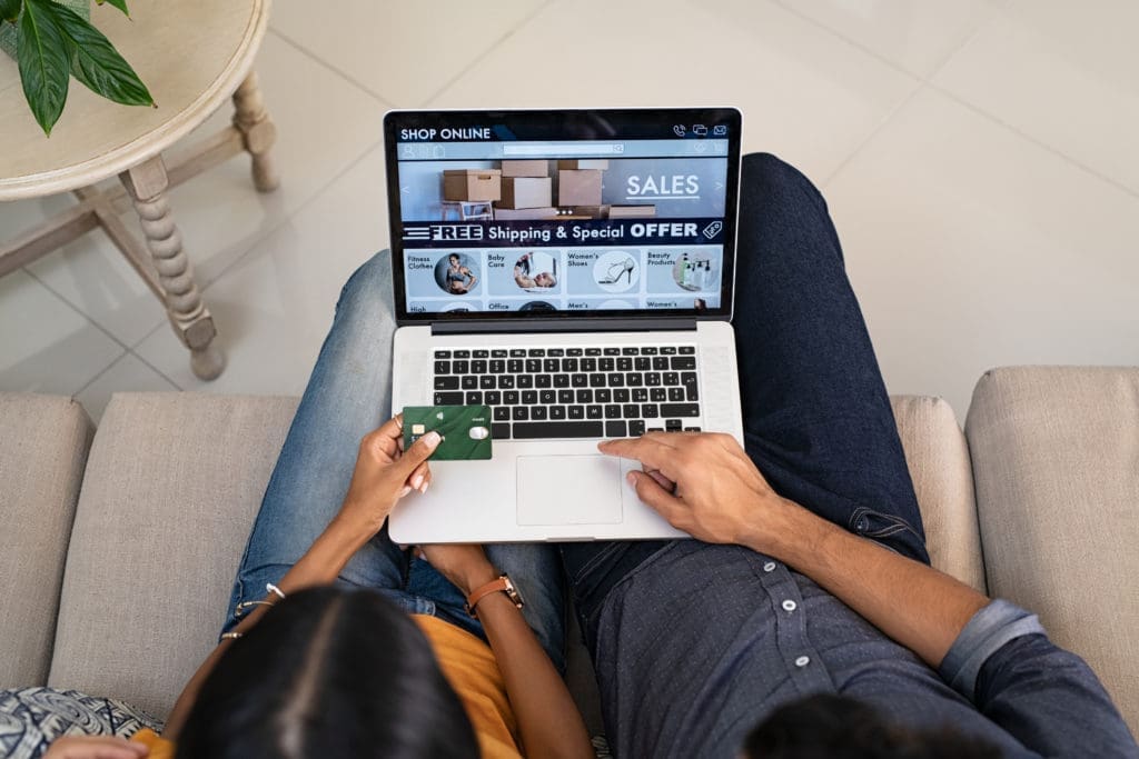 Couple doing shopping online on website with laptop at home.