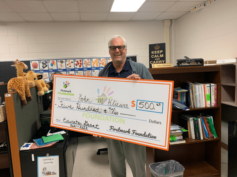 Teacher holding donation check